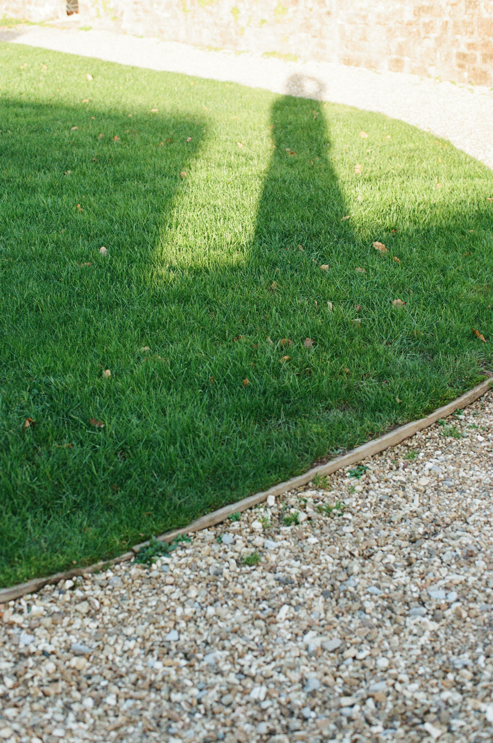 Shadow of a person on a grassy lawn